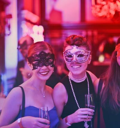 women drinking wine at a masked wine festival