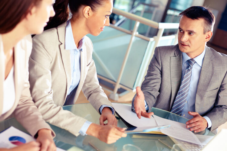 business consultant working with two women in a conference room.