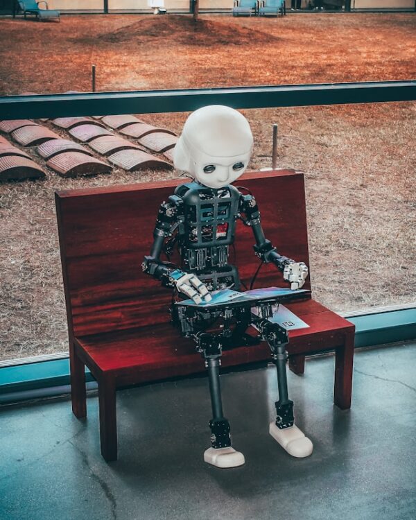 robot sitting on a bench with a tablet.