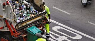 two men working on a garbage truck.