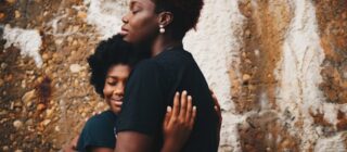 black woman hugging a teen girl.