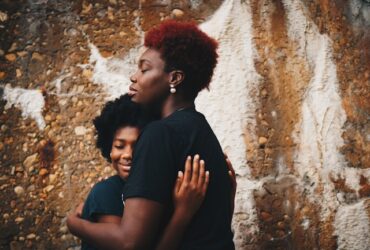 black woman hugging a teen girl.