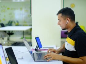 Man working on a laptop in an open office.