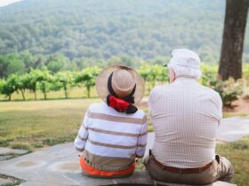 elderly couple sitting and looking at a beautiful landscape.