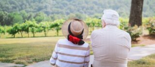 elderly couple sitting and looking at a beautiful landscape.