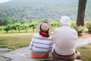 elderly couple sitting and looking at a beautiful landscape.