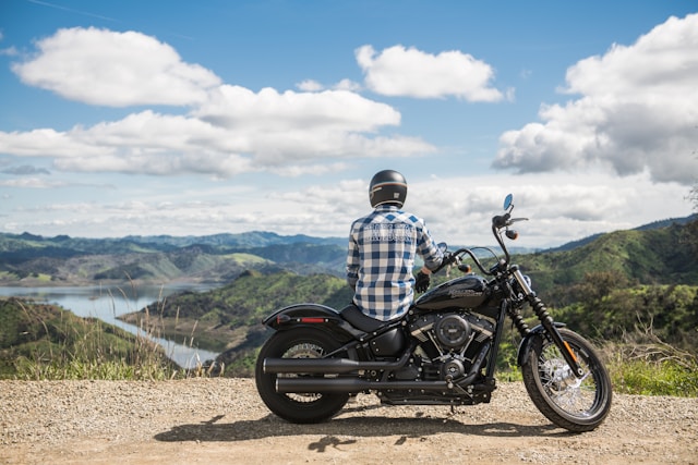 man resting on his bike and looking over a mountain lake.