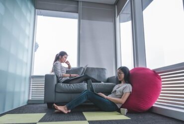 two young women sitting in a lounge area.