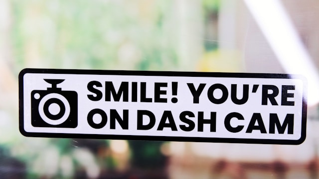 A sticker that says, "Smile! You're on Dash Cam".