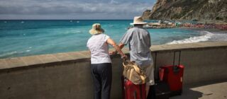 elderly couple on holiday looking out at the ocean.