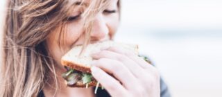 young woman eating a sandwich.