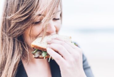 young woman eating a sandwich.