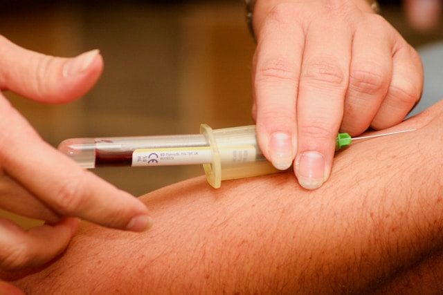 nurse taking blood from a patient's arm.