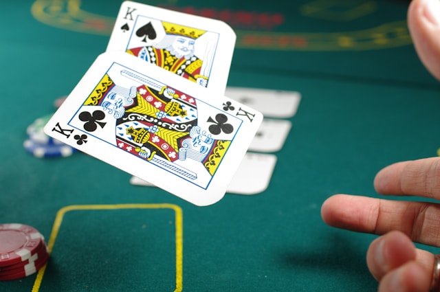 hand throwing out a pair of kings during a poker game.