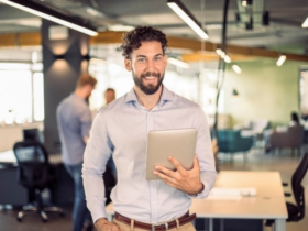 smiling man holding a tablet.