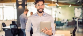 smiling man holding a tablet.