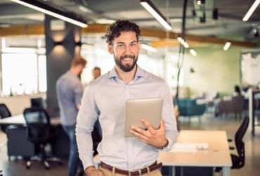 smiling man holding a tablet.