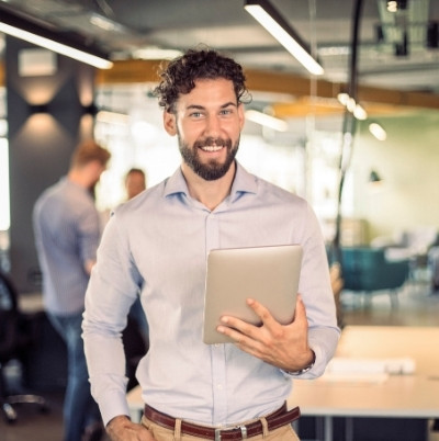 smiling man holding a tablet.