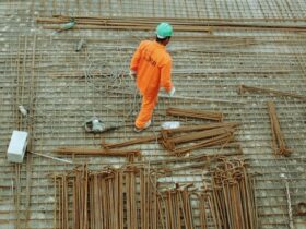 man walking over rebar at a construction site.