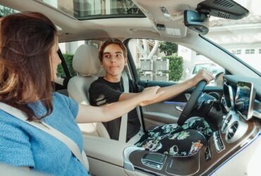 woman teaching a young man how to drive.