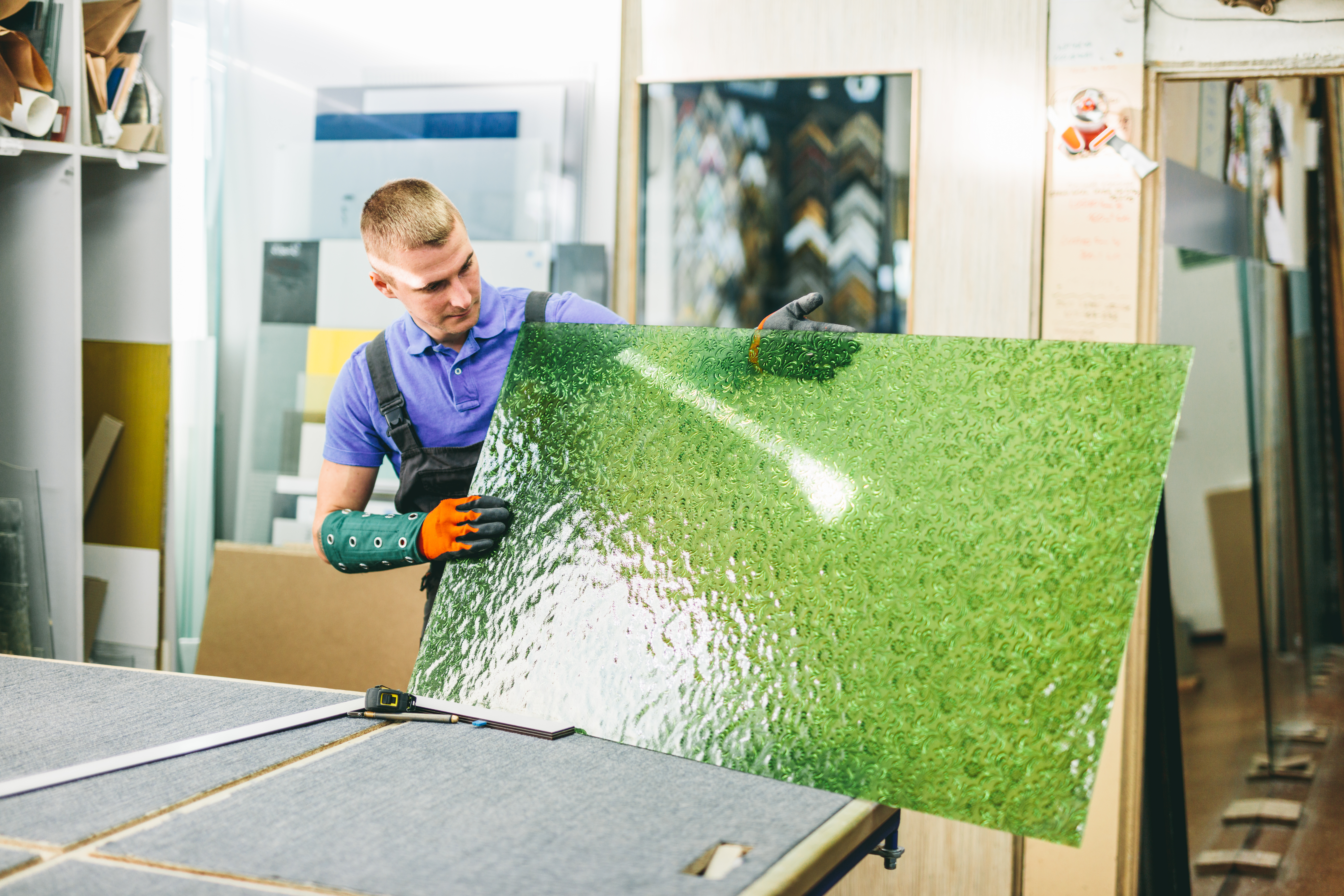 worker holding green glass pane