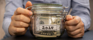 woman's hands holding jar of money