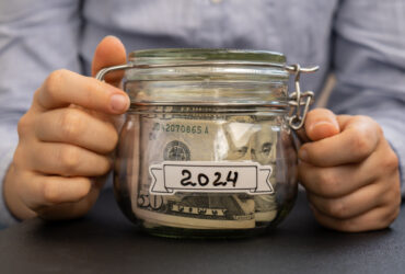 woman's hands holding jar of money