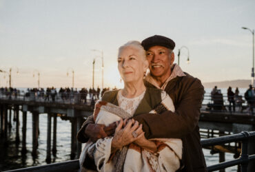 elderly couple by the sea embracing