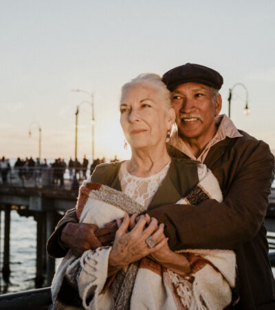 elderly couple by the sea embracing