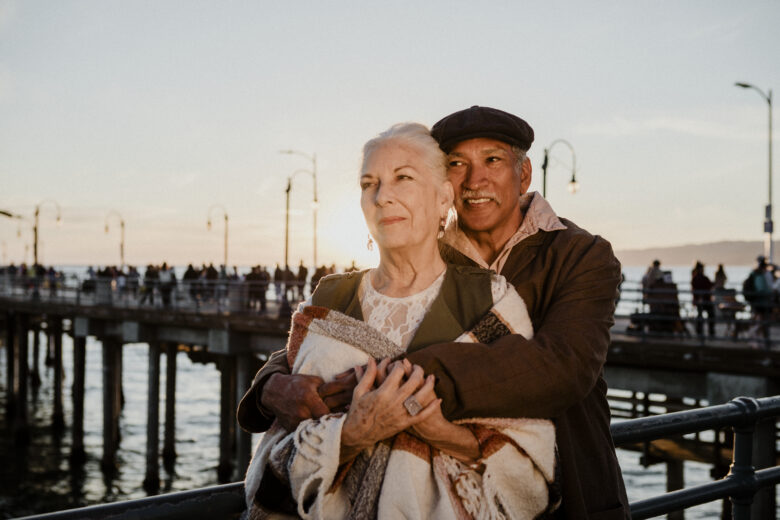 elderly couple by the sea embracing