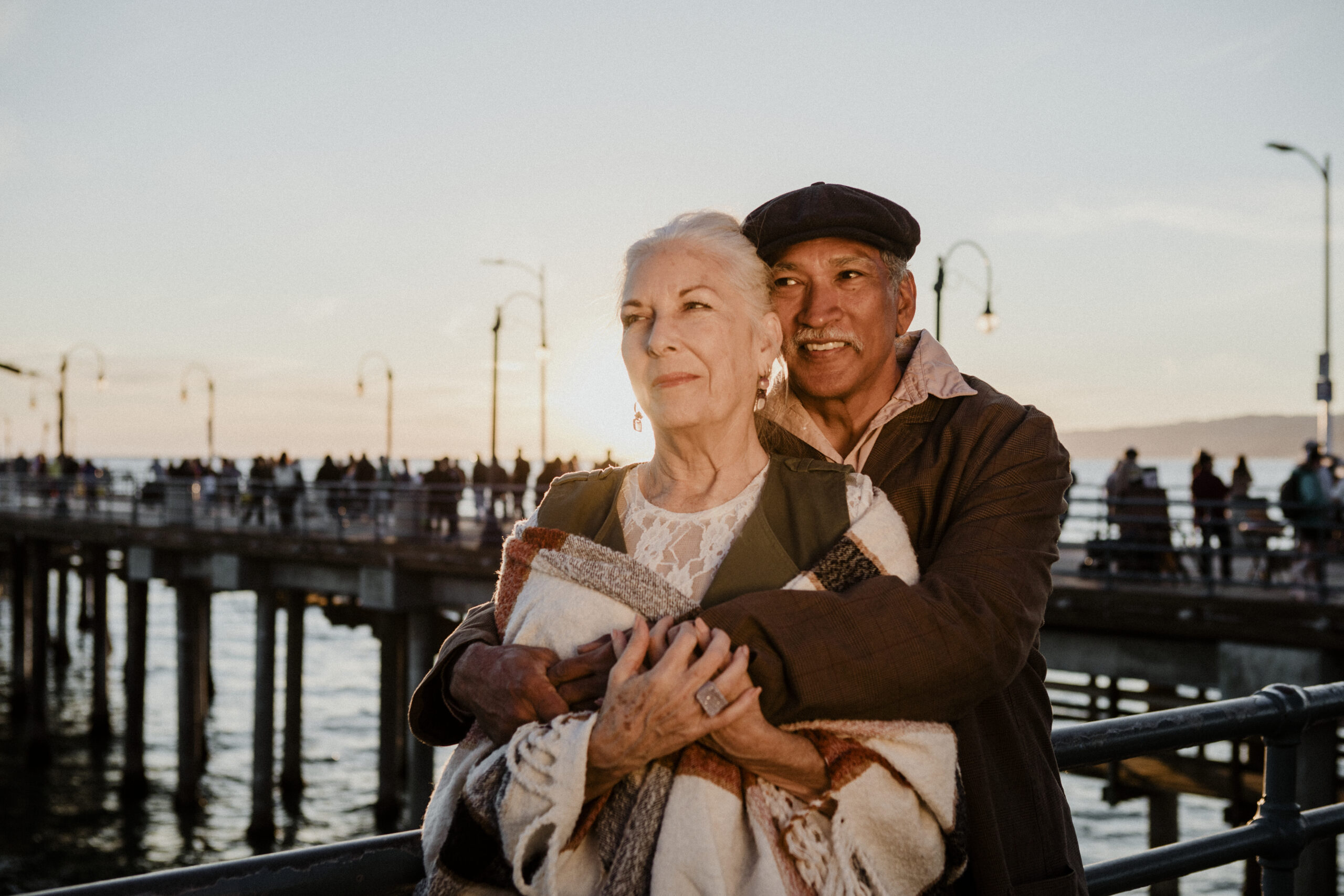 elderly couple by the sea embracing