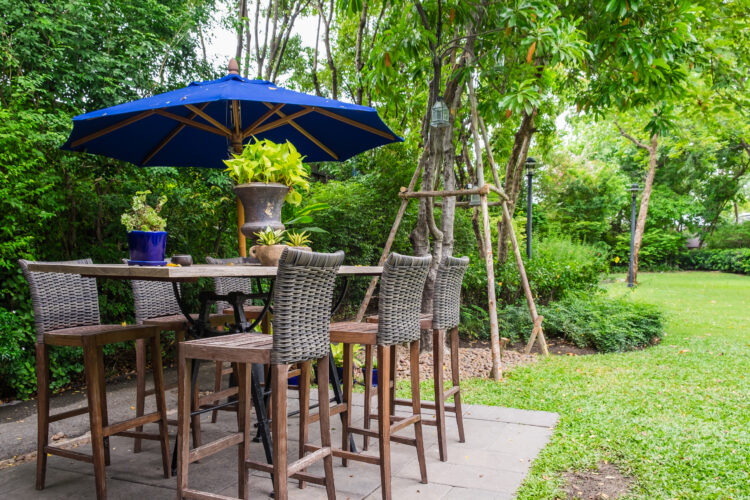 outdoor bar with blue umbrella and wicker chairs